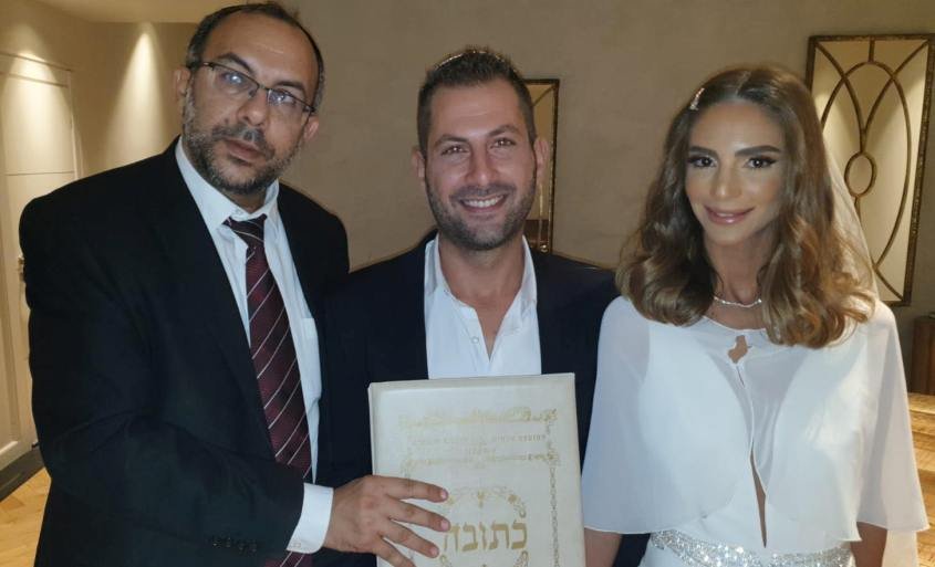 הרב אביטן מחזיק את הכתובה של הזוג