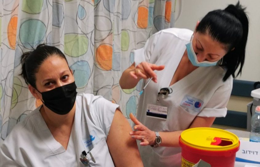 עובדת בברזילי מקבלת את החיסון לקורונה עם תחילת מבצע החיסונים. צילום: דוד לוי