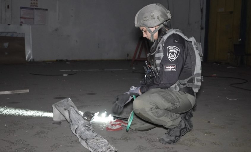 חבלנית משטרה מפנה את הרקטה. צילום: דוברות המשטרה