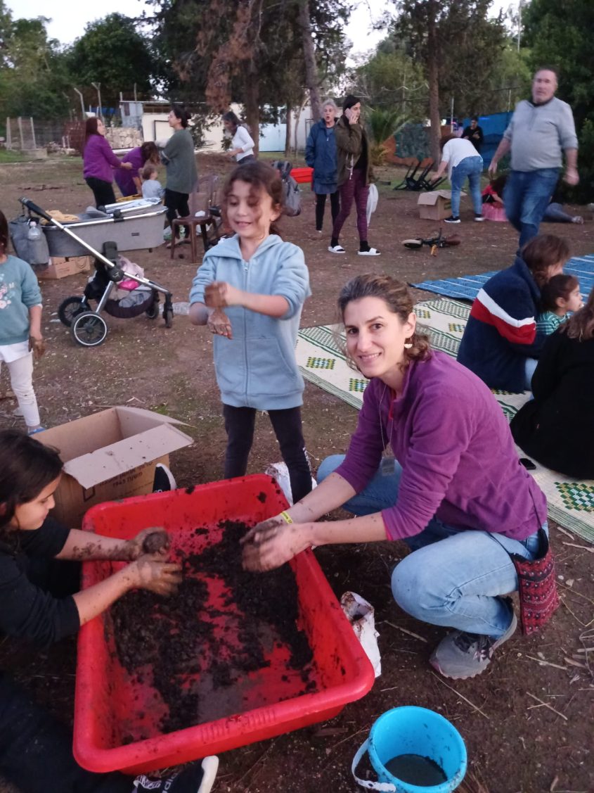 תושבי קיבוץ גבים מכינים כדורי הזרעים. צילום: ניצן בן טל