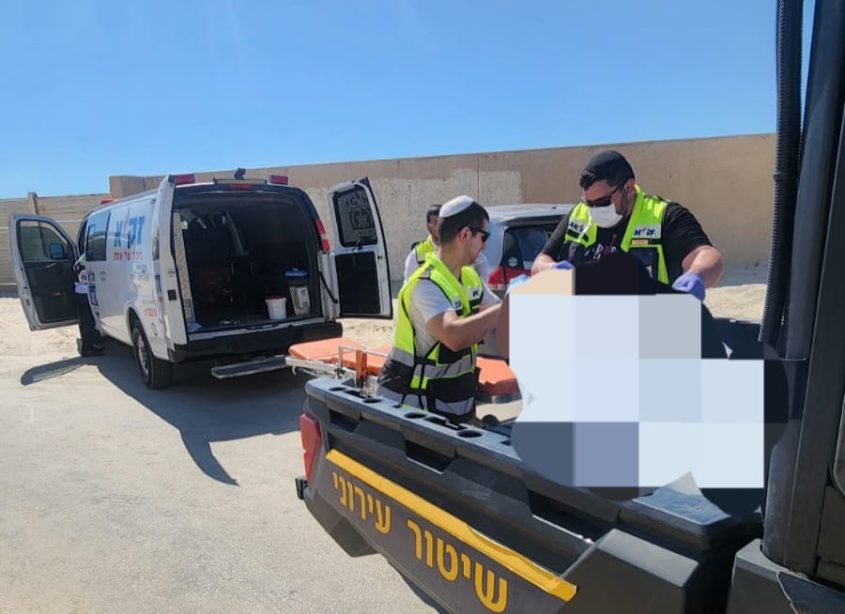 צוות של זק"א מטפל בגופה בחוף הים. צילום: דוברות זק"א